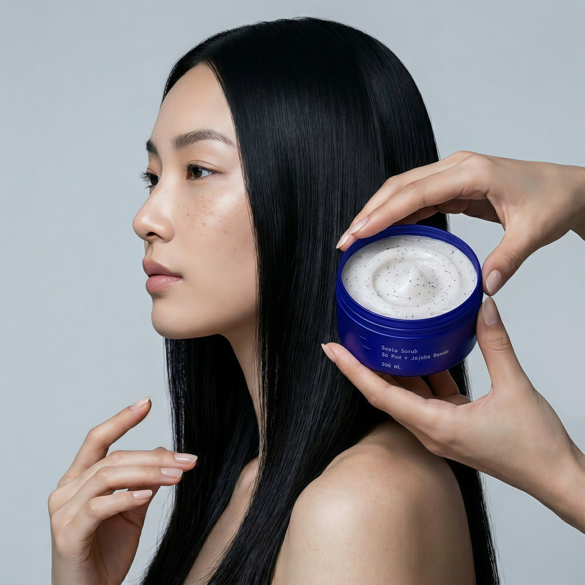 Person with long black hair holding blue purifying mask container