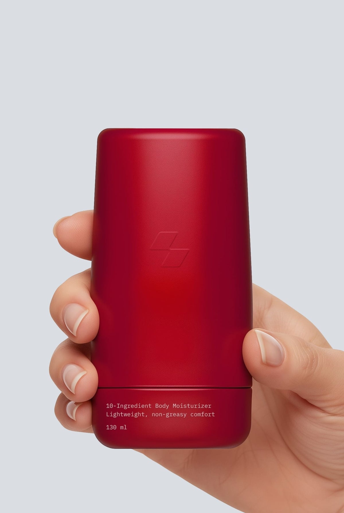 Red cylindrical container held in a hand against a light gray background