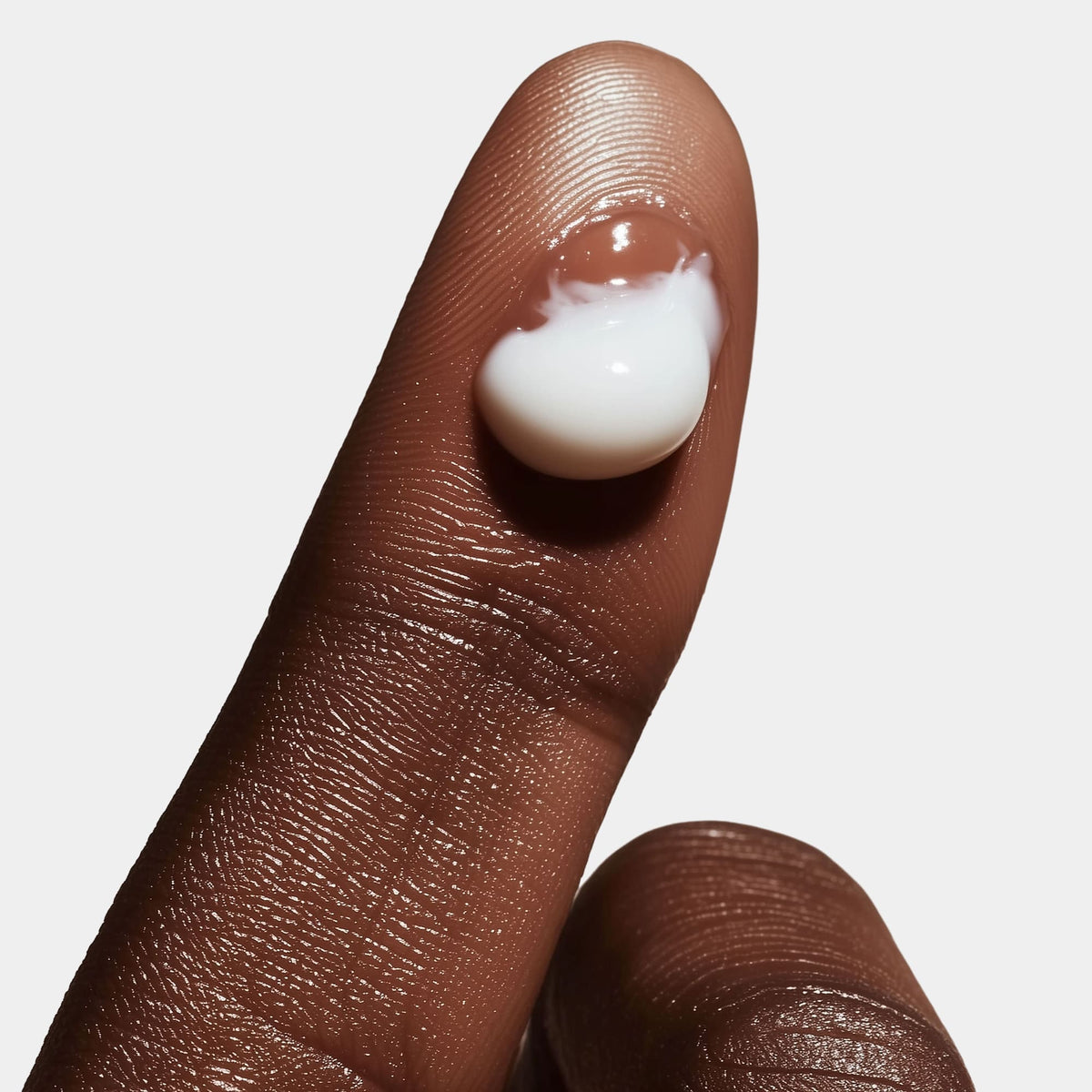 Close-up of a hand applying cream to a person's face
