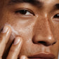 Close-up of a person applying cream to their face