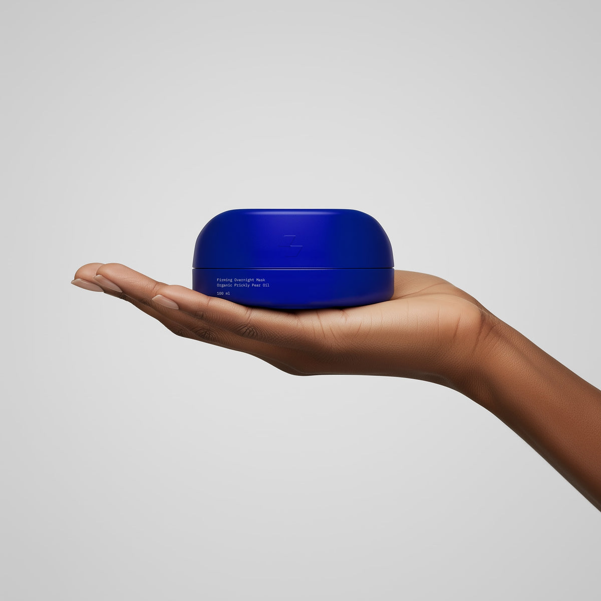 Hand holding a blue container against a light gray background