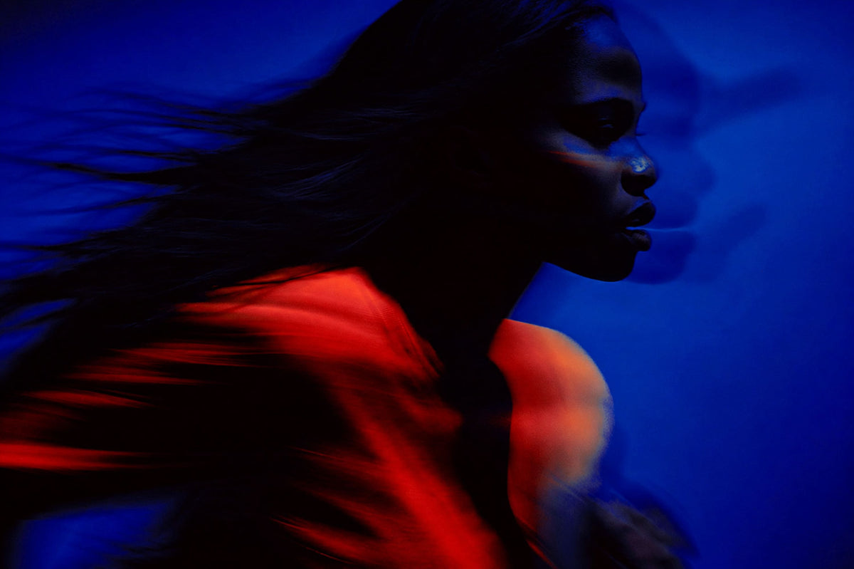 Woman silhouette with flowing hair in blue and red neon lighting