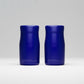 Two blue cylindrical containers on a light gray background