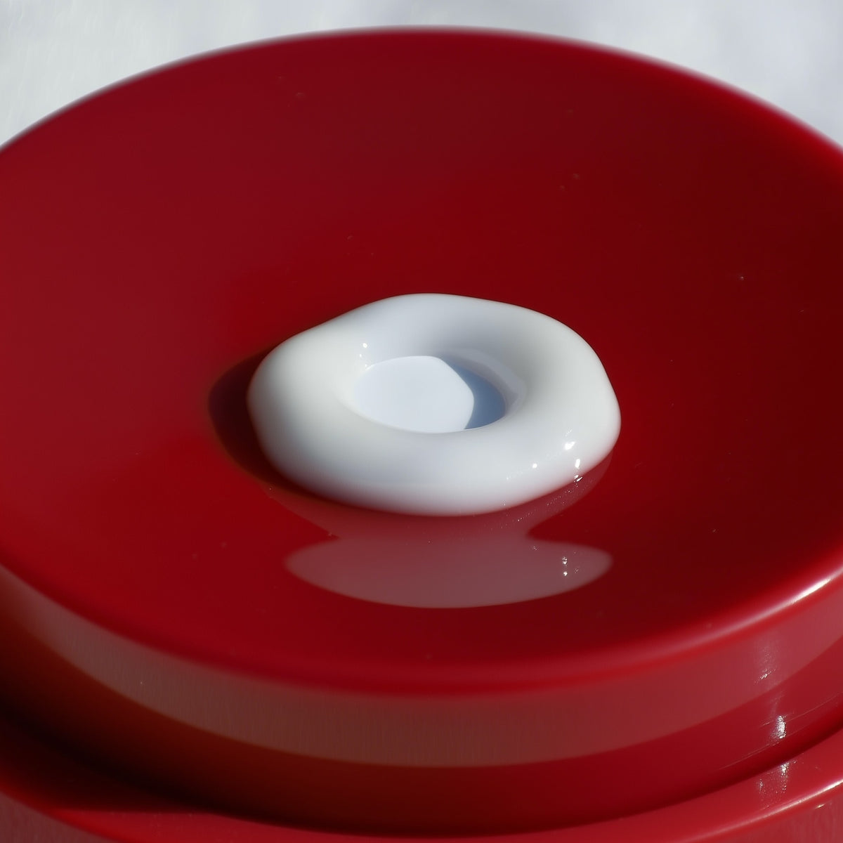 White donut-shaped object on a red surface