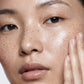 Close-up of a person's face with a neutral expression on a plain background