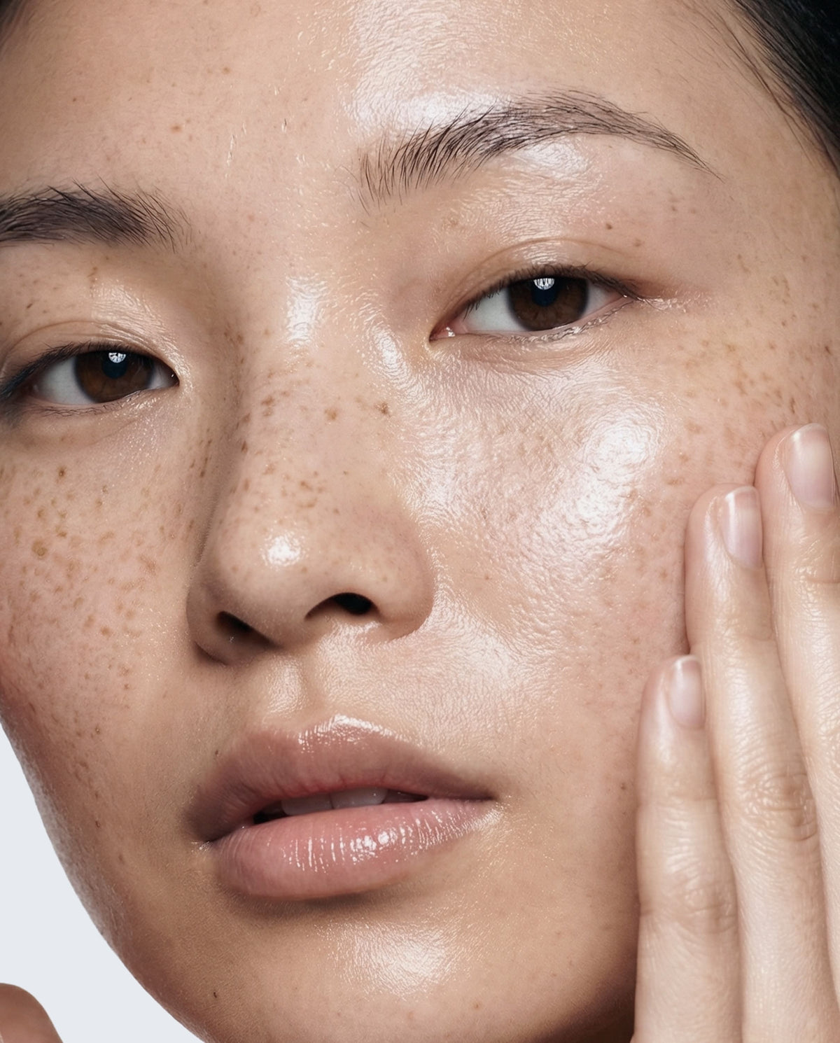 Close-up of a person's face with a neutral expression on a plain background