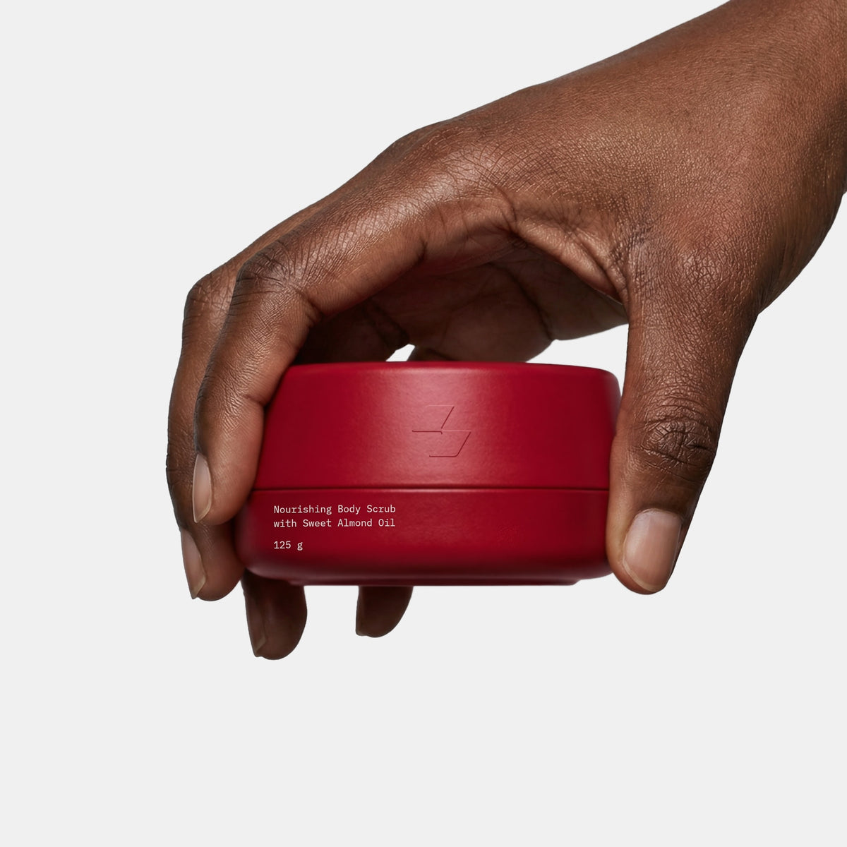 Hand holding a red container with text on a white background