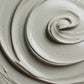 White exfoliating face mask with dark particles and swirled texture