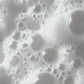 Macro view of white foaming product with various sized bubbles