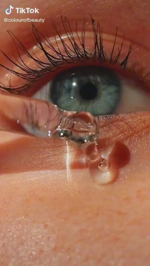 Close-up of eye with long black lashes and hydrating moisture droplets on skin