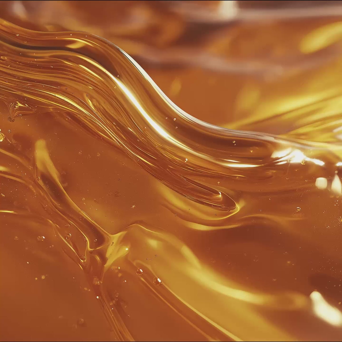 Golden amber oil with flowing texture and bubbles