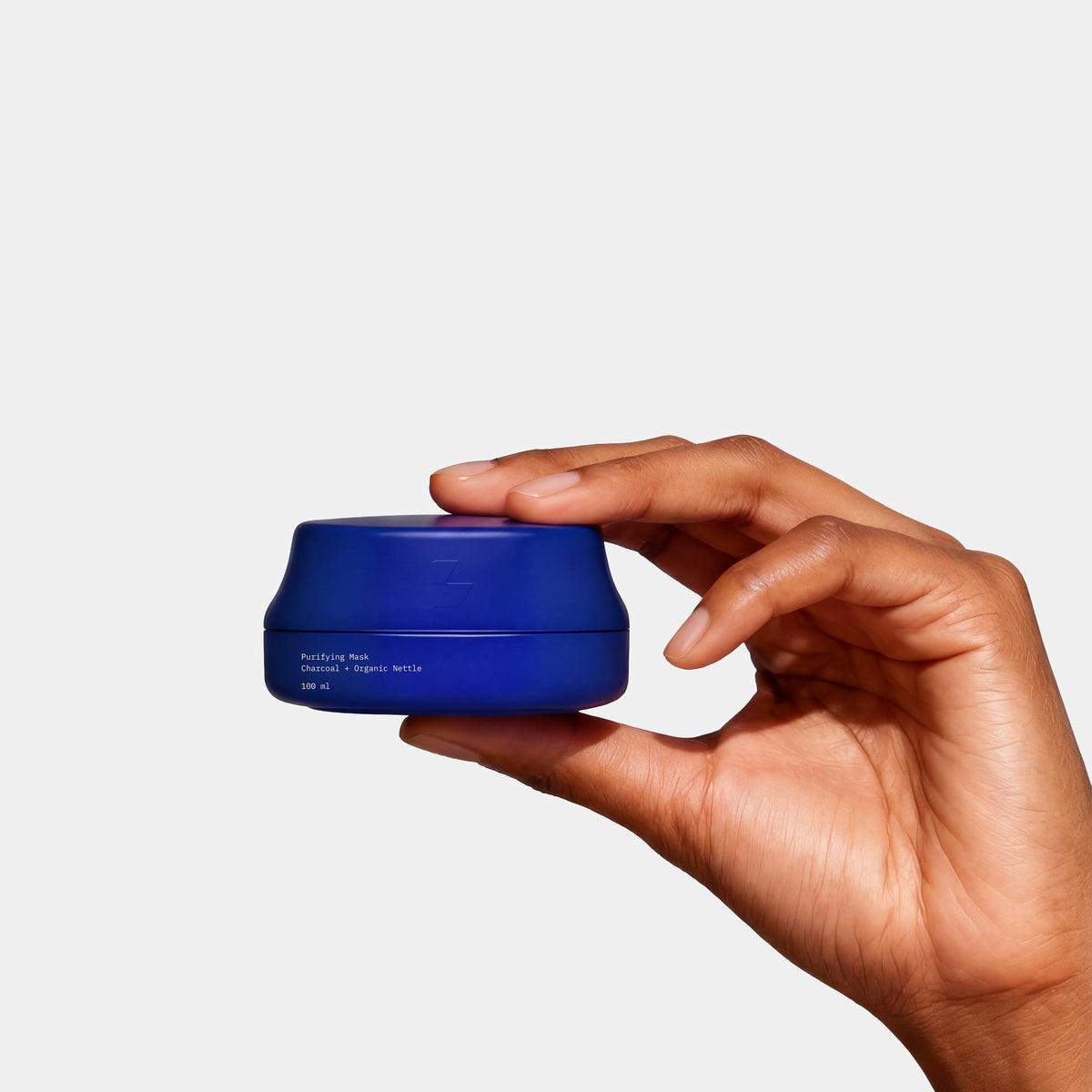 Hand holding a blue container against a white background