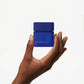 Hand holding a blue container against a white background