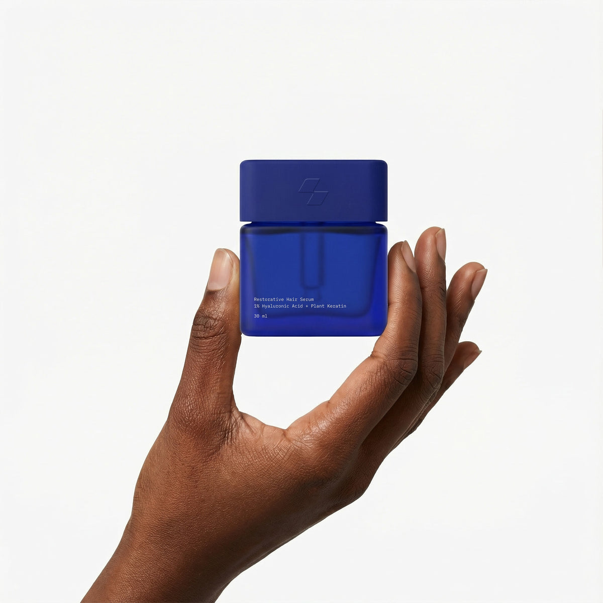 Hand holding a blue container against a white background