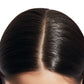 Close-up of a person's scalp with shiny, well-maintained hair.