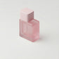 Pink perfume bottle on a light gray background
